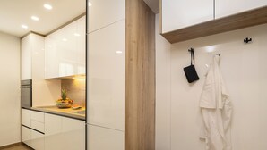 A modern kitchen with white cabinets, a wooden countertop, and a fruit bowl. - La Perla - Downtown House (Omiš)
