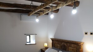 Ein Schlafzimmer mit einem hölzernen Bett, zwei Nachttischlampen, einem Fenster und einem Holzkopfende.