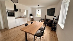 A modern apartment with a kitchen, dining area, and living room.