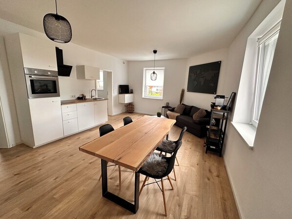 Um apartamento moderno com cozinha, sala de jantar e sala de estar.
