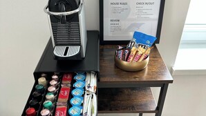 A bar cart with various bottles, a coffee machine, and snacks.