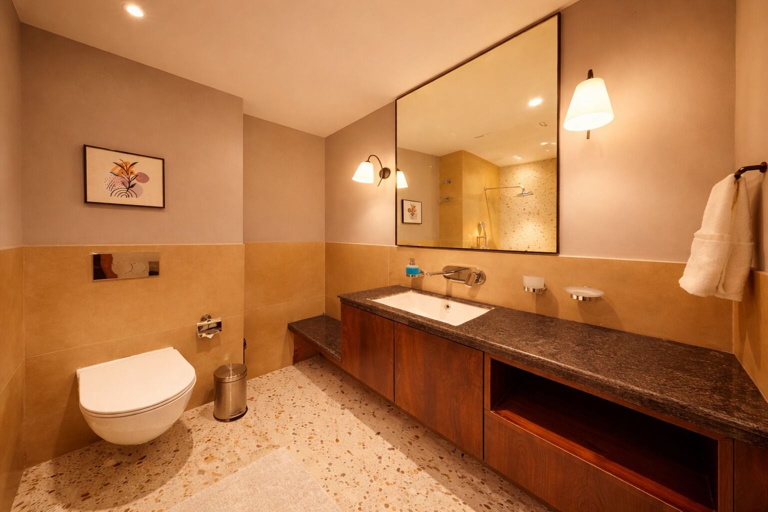 Un baño con inodoro, lavabo, espejo y barra para toallas.
