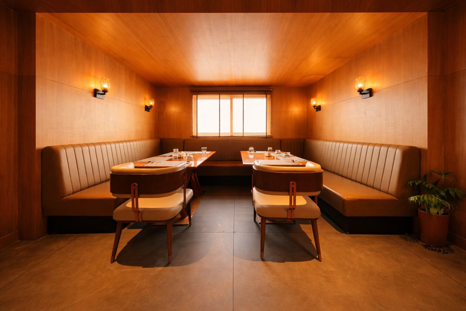 A dining area with wooden walls, a central table, and seating on both sides.