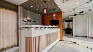 Een receptiebalie met een modern design, met een houten paneel en een witte toonbank.