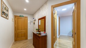 Ein Flur mit Holztüren, einem Holzschrank und einem Spiegel.