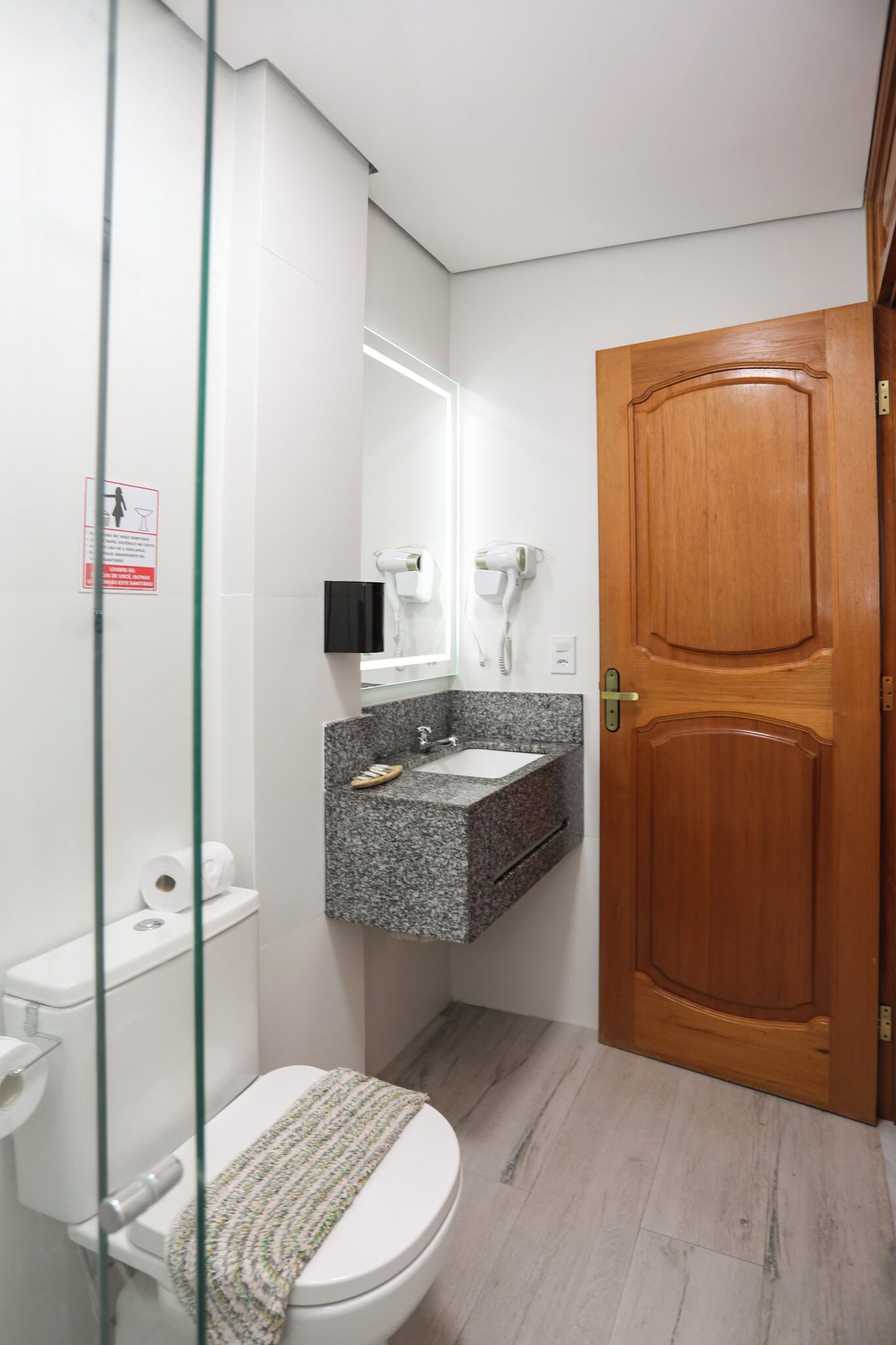 A bathroom with a toilet, sink, and a shower area.