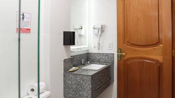 A bathroom with a toilet, sink, and a shower area.