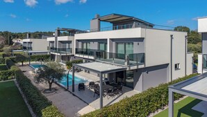 A modern multi-story residential building with a rooftop pool, outdoor seating, and a clear view of the surrounding landscape. - Villa Centinera With Private Pool (Medulin)