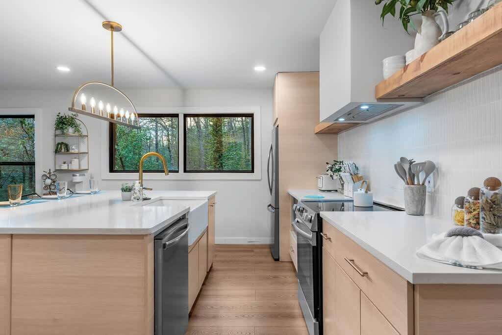 A modern kitchen with a central island, built-in appliances, and a pendant light.
