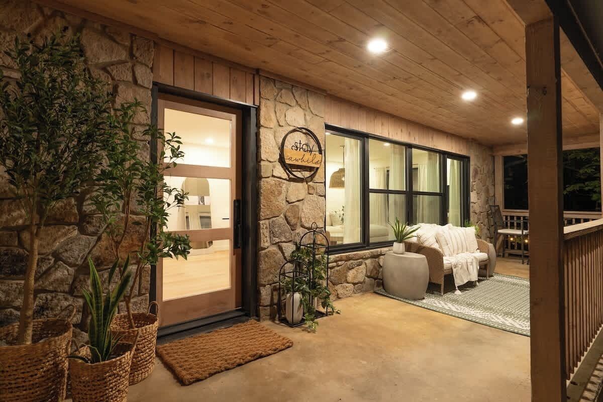 A cozy interior with a stone wall, a wooden ceiling, and a seating area with a sofa and a table.
