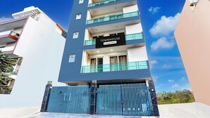 Un edificio de varios pisos con un cartel que dice "TOWNHOUSE" y una entrada con portón.