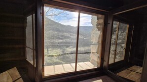 A room with a large window offering a view of a mountainous landscape.