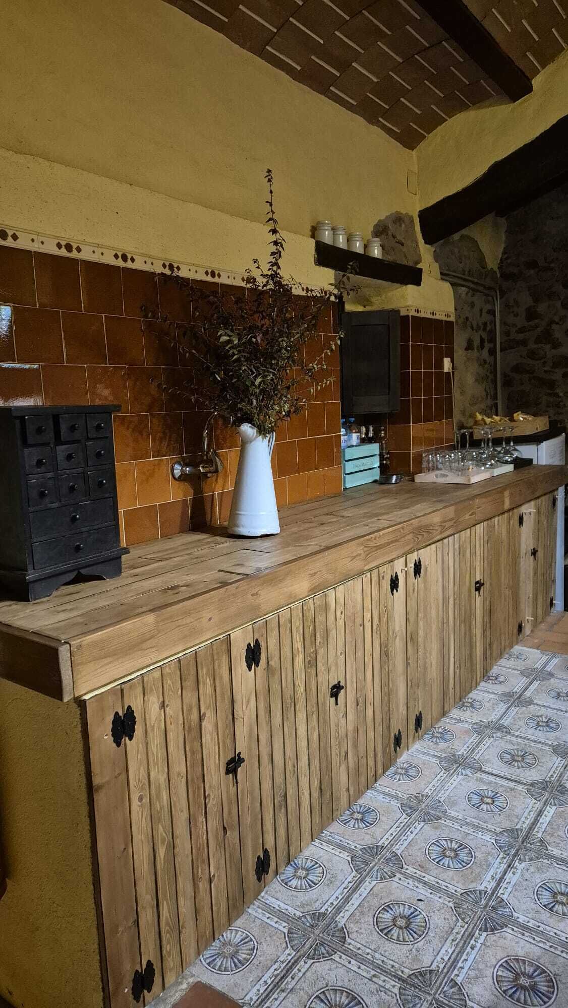 A kitchen with a wooden counter, a potted plant, and a tiled backsplash.