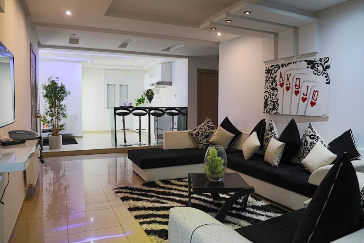 A modern living room with a sofa, coffee table, and a decorative wall piece.