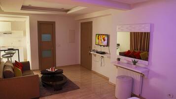 Una sala de estar moderna con sofá, mesa de centro, televisor y espejo.
