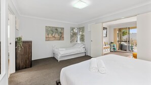 A bedroom with a large bed, a smaller bed, a desk, and a window with blinds. - Prime Location Crown, Train&City (Lathlain)
