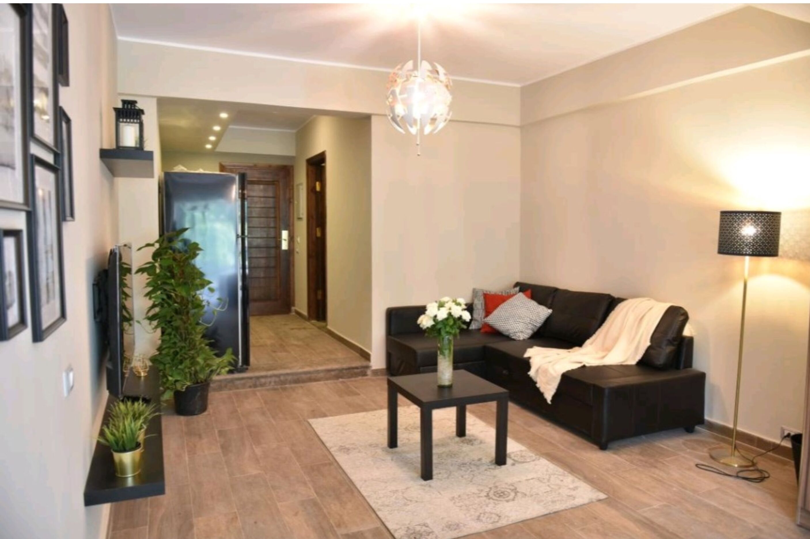 Un salon comprenant un canapé, une table basse, un lampadaire et un lustre.