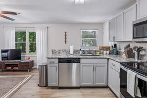 A modern kitchen with a dishwasher, microwave, and stove.