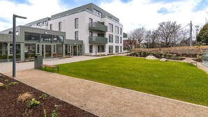 A modern building with a flat roof, large windows, and a well-maintained lawn in front. - The Lookout by Dublin At Home (Dublin)