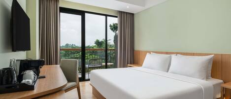 Ein Hotelzimmer mit Bett, Schreibtisch, Stuhl, Fernseher und einem Balkon mit Blick.