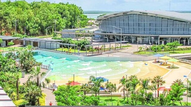 A modern hotel with a large pool, a beach area, and lush greenery. - Zen City Tropics Fenced Yard - Balcony - Desk (Darwin)