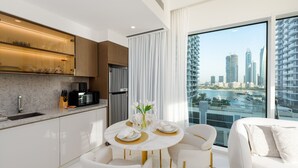 Ett modernt kök med matplats, ett stort fönster med utsikt över staden och en vit soffa.