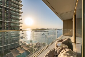 Ein Balkon mit Blick auf ein Gewässer und eine Stadtansicht.