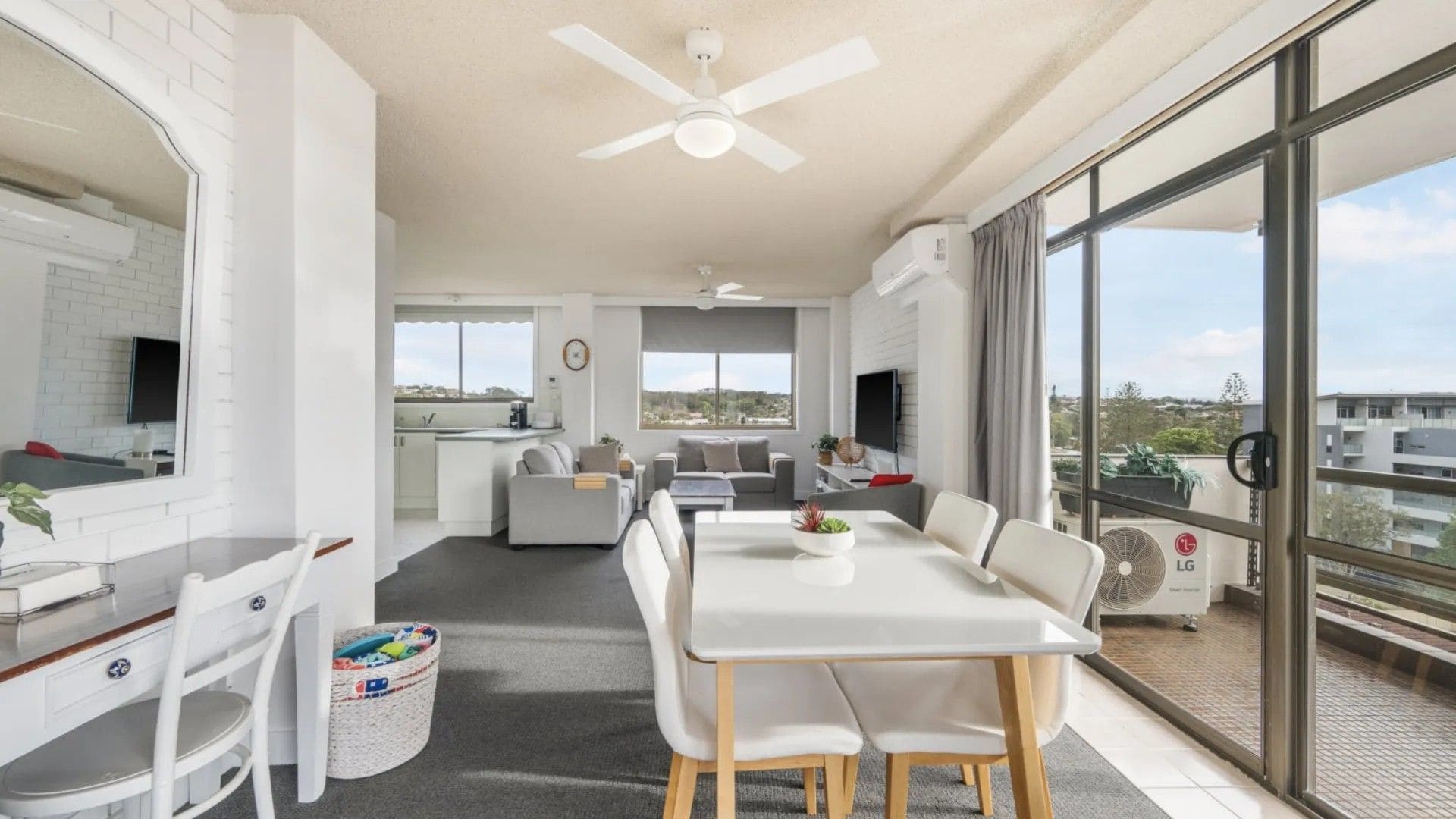 A modern living space with a dining area, kitchen, and seating area.