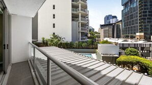 A modern residential building with a balcony, a pool, and surrounding greenery. - Brisbane City Retreat With Private Balcony (Brisbane)