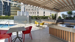 An outdoor pool area with a covered seating area, a pool table, and a bar. - Brisbane City Retreat With Private Balcony (Brisbane)