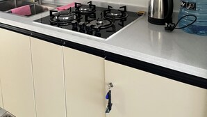 A kitchen with a gas stove, a kettle, a water dispenser, and a sink. - Modern studio close to JKIA and SGR Syokimau (Nairobi)