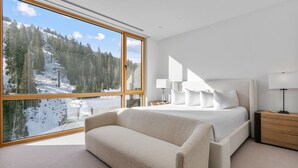 A modern bedroom with a large window, a bed, a bedside table, and a sofa. - Ski-in/out Deer Valley Resort Pool 3br 3 Bedroom Condo (Park City)
