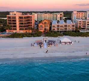 Ein Strandhotel mit mehreren Gebäuden, einem Pool und einer Veranstaltungseinrichtung direkt am Strand.