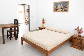 A bedroom with a wooden bed, a wooden nightstand, a bedside table, a chair, and a desk. - Villa de luxe, Cuisine Equipée, Piscine Privée, 2 salles de bains, Nosy Be (Nosy Be)