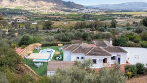 A villa with a swimming pool, outdoor seating, and a view of the surrounding landscape. - Beautiful 3-bedroom villa with AC and private pool in Pizarra (Pizarra)
