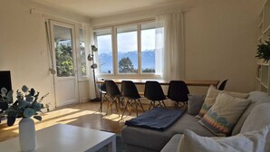 Una sala de estar con sofá, una mesa de centro y un comedor con sillas y mesa.