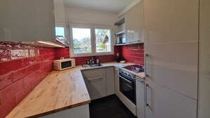 Una cocina compacta con microondas, fregadero y horno.