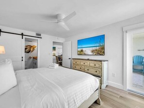 A bedroom with a bed, a dresser, a ceiling fan, a TV, and a door leading to a balcony. - 511- Gulf-Front Destin🌊 Free Bch Svc✨Newly Remodeled/New to Rental Program! (Destin)