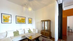 Sala de estar com sofá, mesa de centro e um aparador de madeira.