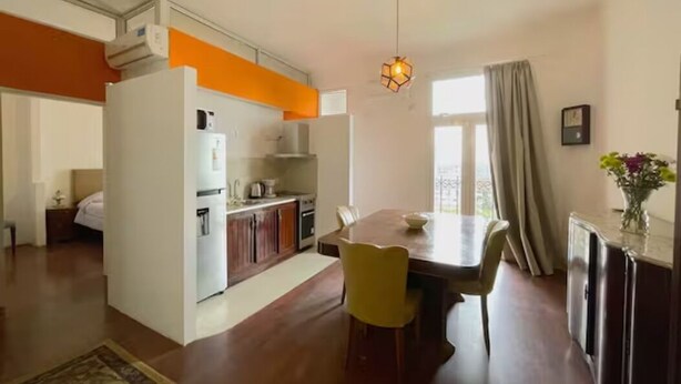 Um espaço compacto com cozinha, área de refeições e um pequeno quarto.