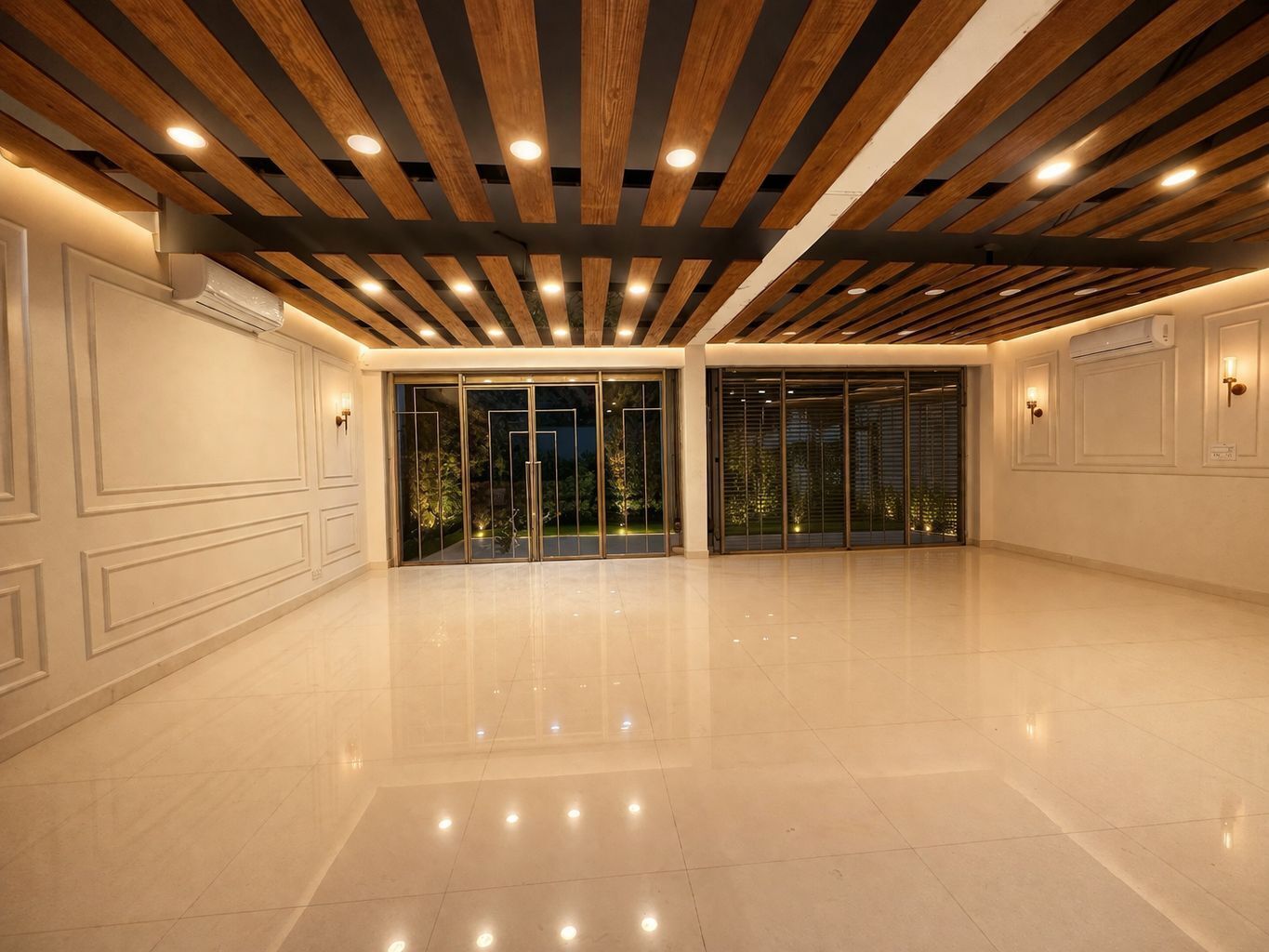 A spacious, well-lit room with a polished floor, wooden ceiling beams, and large glass doors leading to an outdoor area.