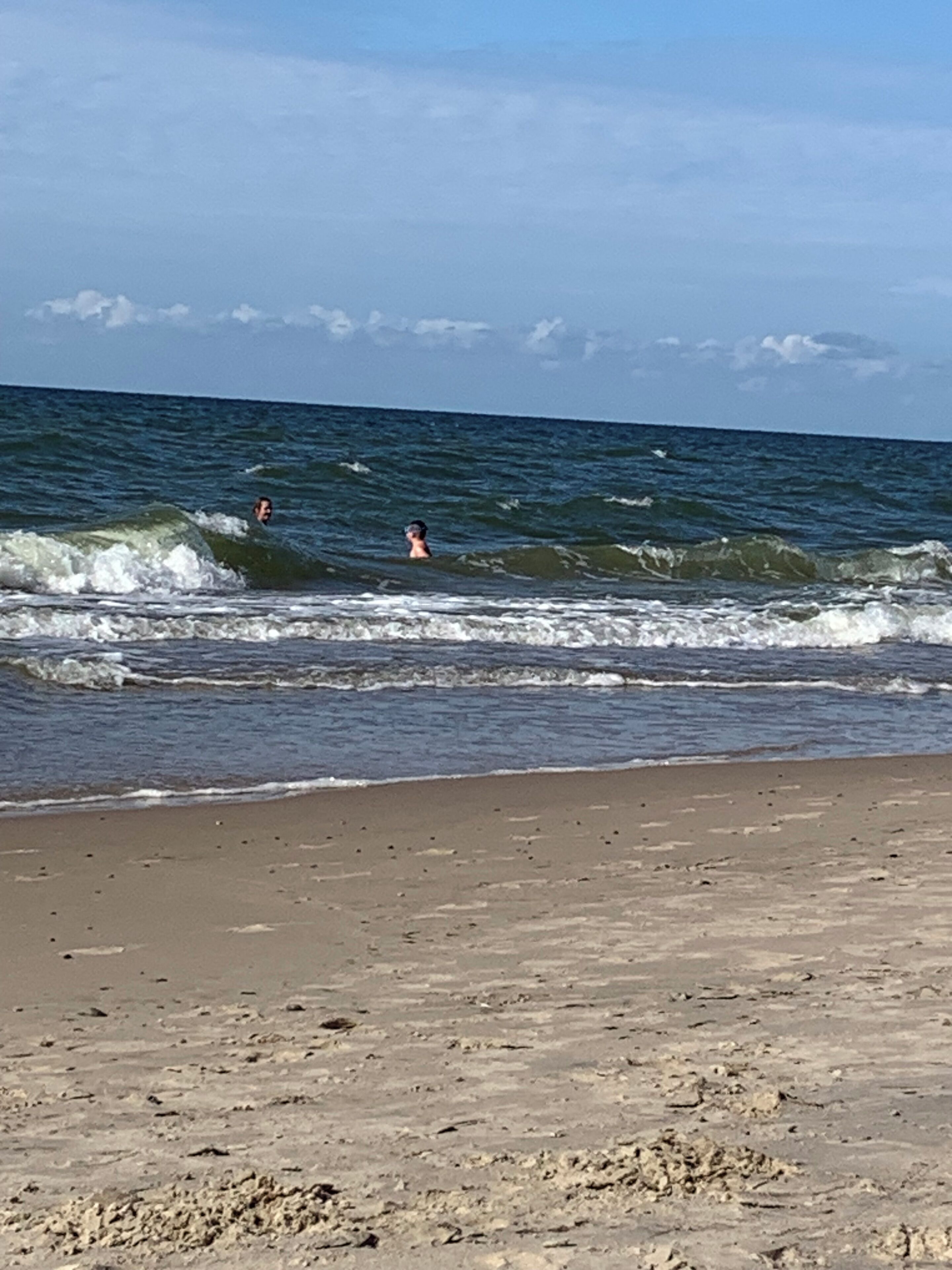 Una playa con olas y cielo despejado.