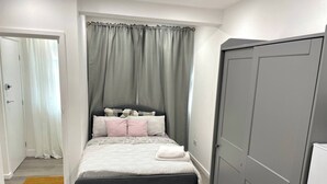 Ein Schlafzimmer mit einem Bett, einem Kleiderschrank und einer Tür zu einem anderen Raum.