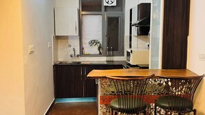 Una cocina compacta con comedor, piso de madera y ventilador de techo.