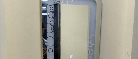 A bathroom with a white sink, a mirror with a decorative frame, and a dark wooden vanity.