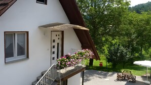 A white building with a brown roof, a balcony with a metal railing, and a small window. - Himmelsbach Apartment with Terrace and Wi-Fi (Gengenbach)