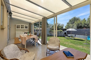 A covered patio with a table, chairs, and a book.