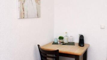 Ein kleiner Essbereich mit einem Tisch, einem Stuhl und einem Bild an der Wand.