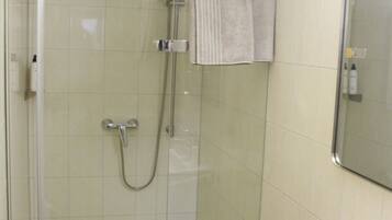 Une salle de bain avec une douche à parois de verre, un lavabo et un miroir.