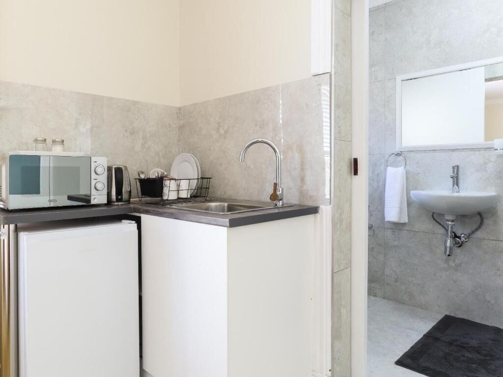 Een minikoelkast, een microgolfoven, kookgerei, borden en bestek